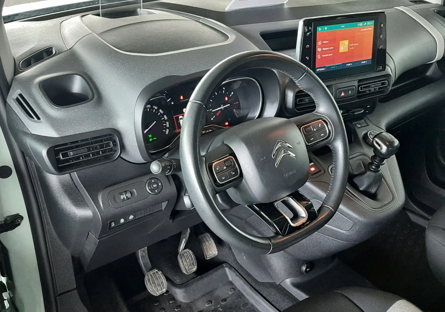 Vue intérieure côté conducteur du Citroën Berlingo 2019, tableau de bord gris noir avec volant multifonction et écran tactile central.