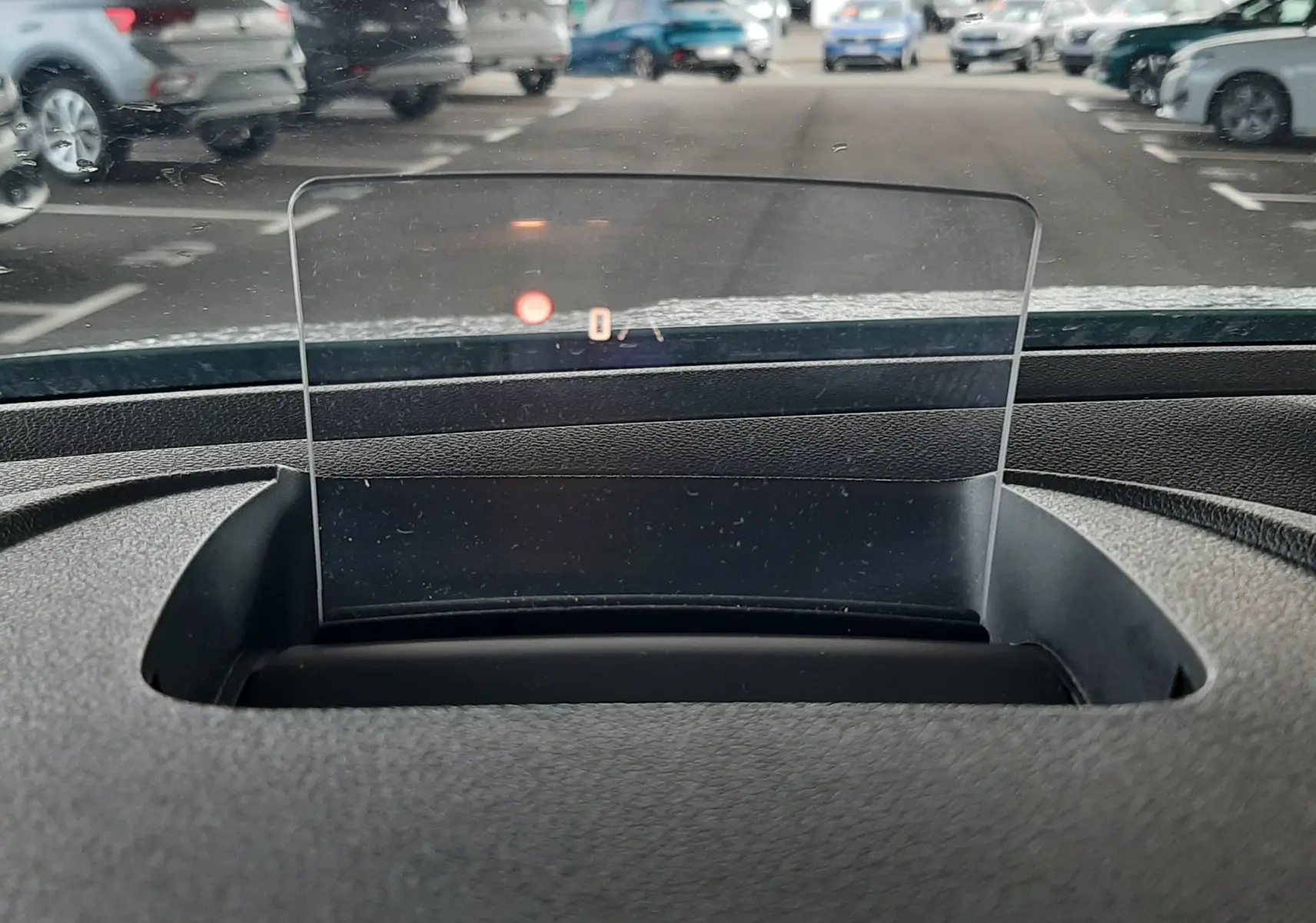 Affichage tête haute transparent du tableau de bord du Citroën Berlingo vert, vue intérieure avant sur parking.