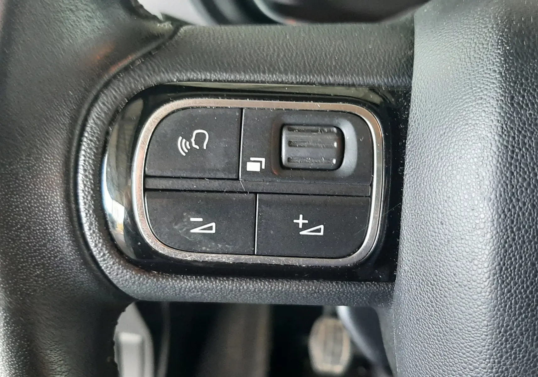 Gros plan sur les commandes au volant du Citroën Berlingo 2019, finition Shine, avec tableau de bord flou en arrière-plan.