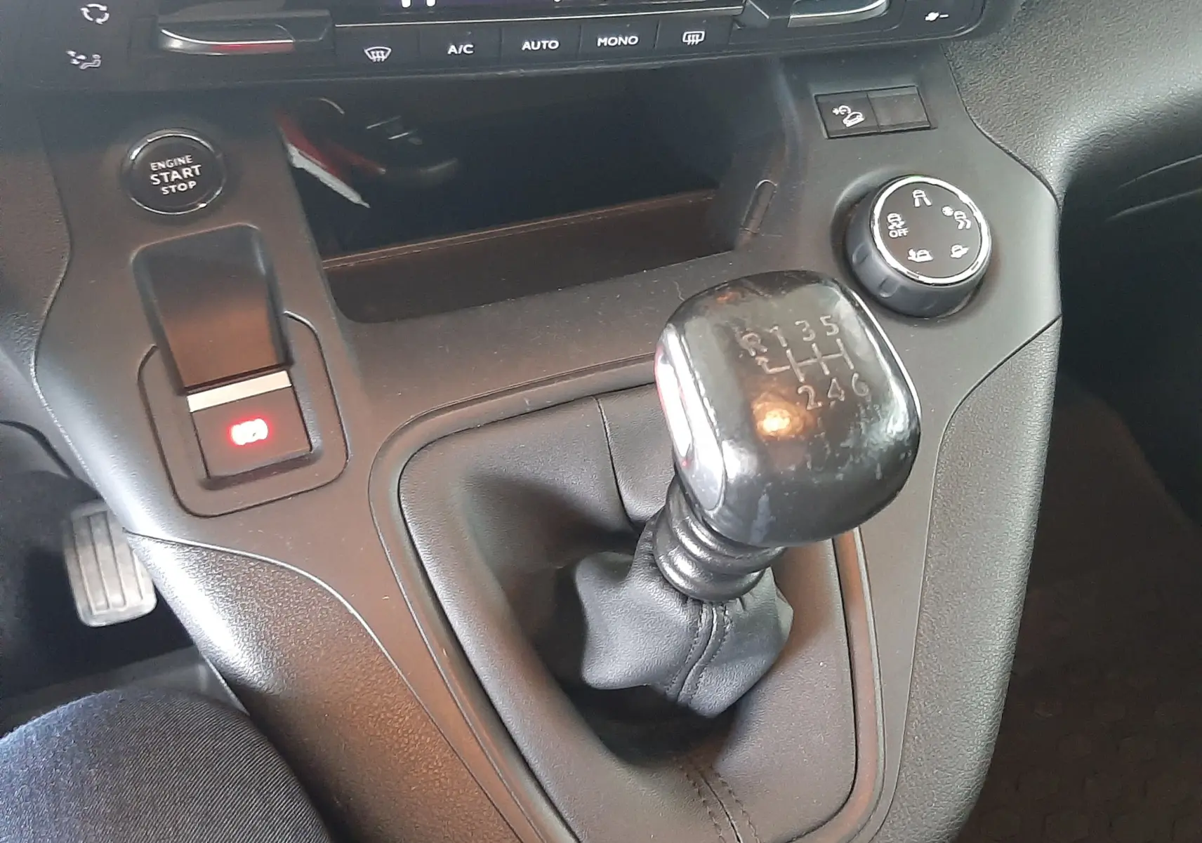 Gros plan sur le levier de vitesses manuel et la console centrale du Citroën Berlingo M BlueHDi 130 Shine, intérieur noir.