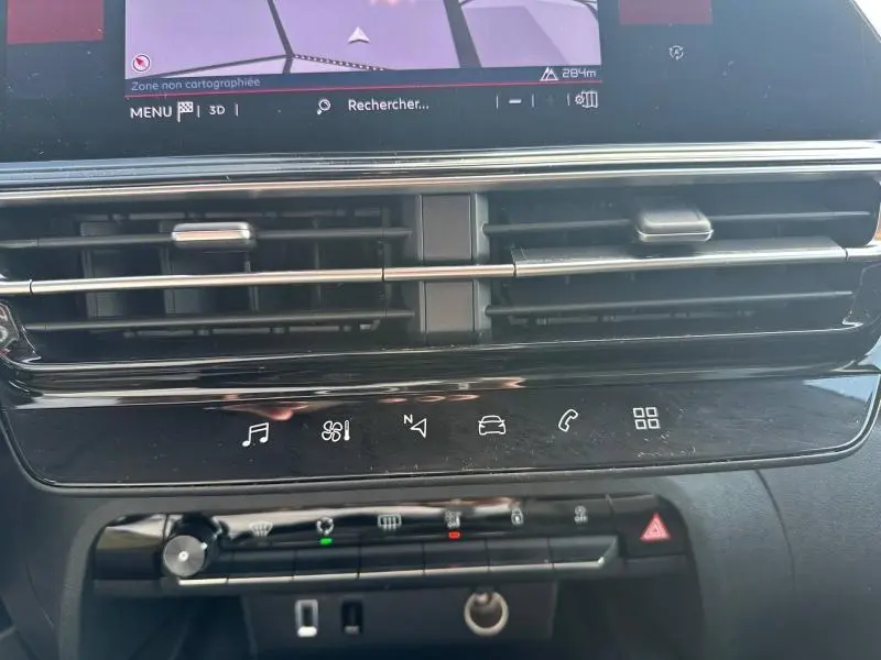Vue rapprochée du tableau de bord noir du Citroën C5 Aircross 2025, avec commandes tactiles et écran de navigation visible.