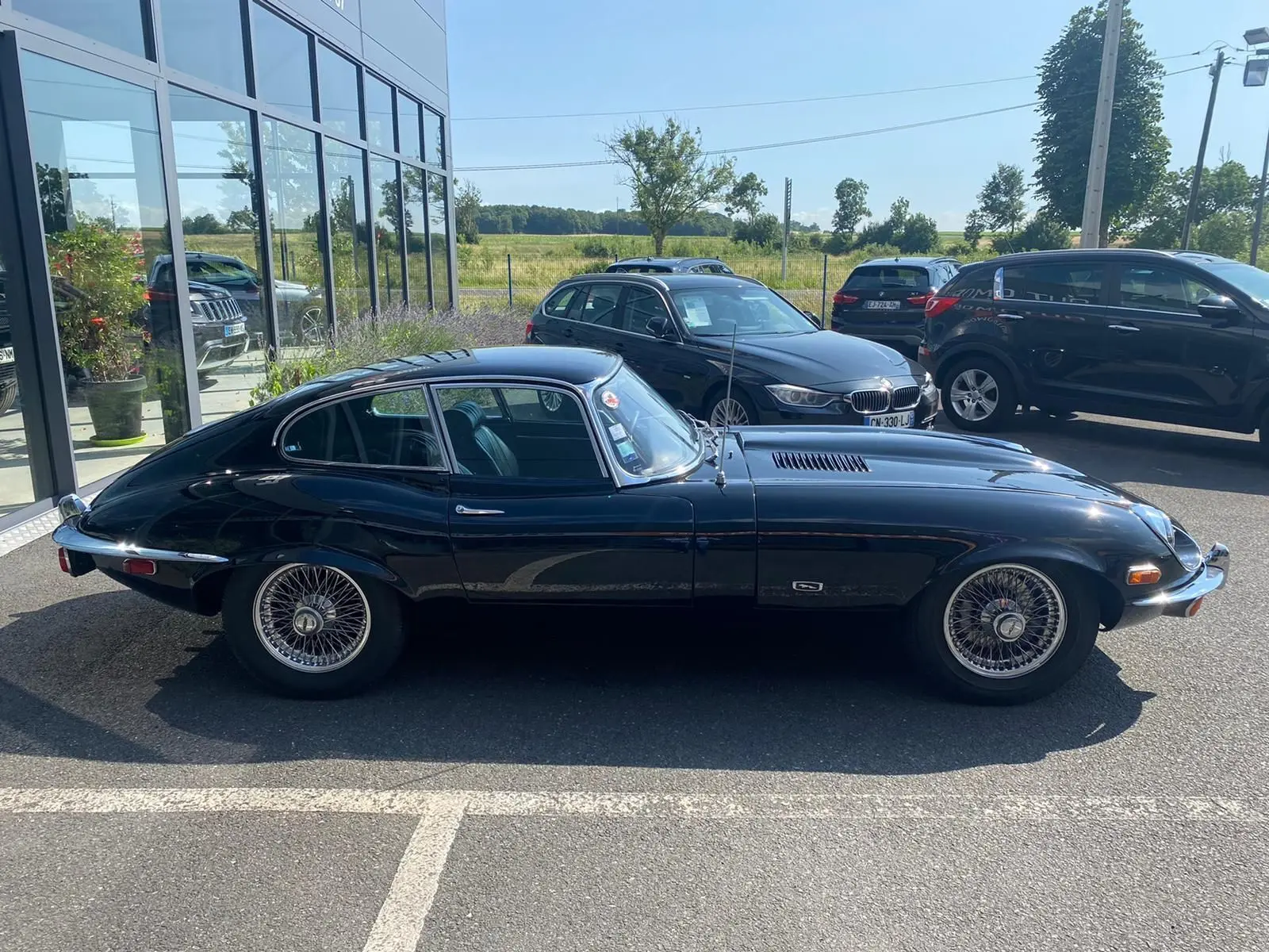 Profil côté gauche d'une Jaguar S-Type Type E Coupé 4.2 Série 2 noire de 1970 avec jantes à rayons classiques.