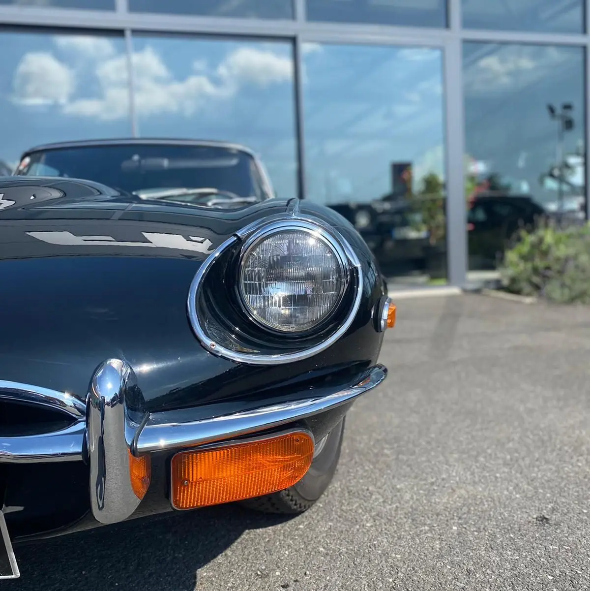 Vue rapprochée avant droite de la Jaguar S-Type noire 1970, avec phare rond et clignotant orange visible.