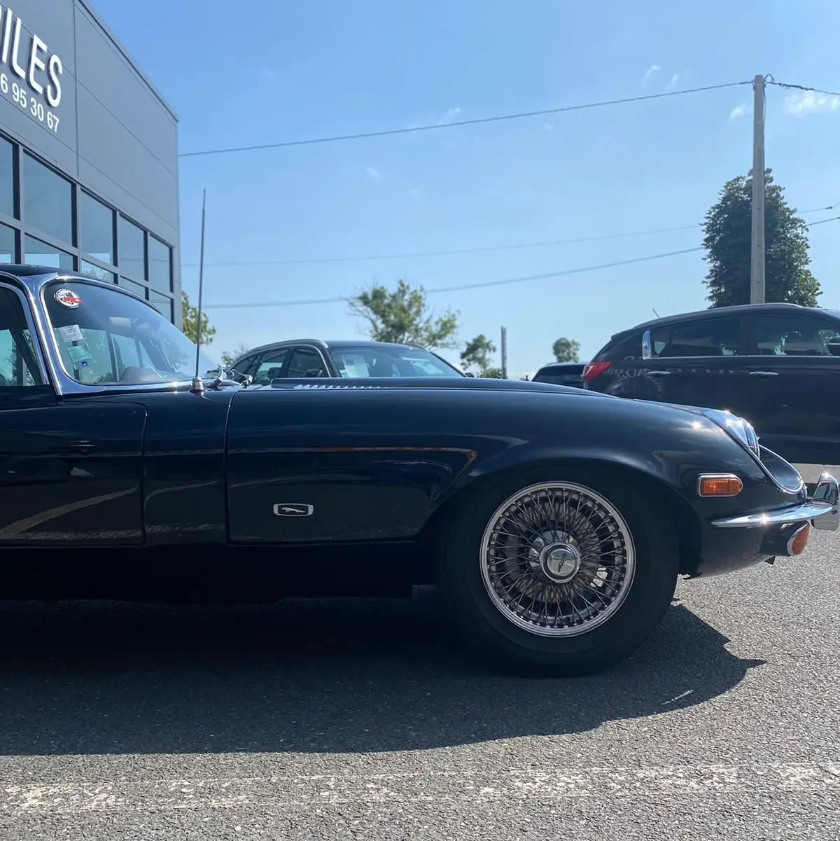 Profil côté gauche d'une Jaguar S-Type Type E Coupé 4.2 noire de 1970 avec jantes à rayons classiques.