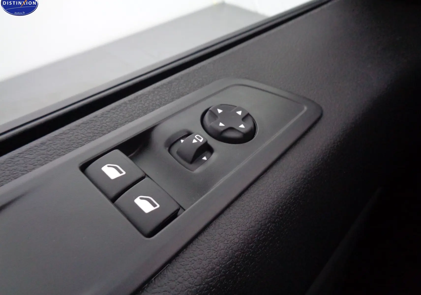 Gros plan sur les commandes de réglage des vitres et des rétroviseurs côté conducteur du Peugeot Expert Long noir perle 2023.
