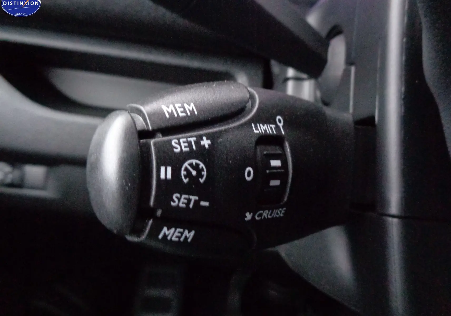 Gros plan sur le commodo de régulateur de vitesse du Peugeot Expert Long noir perle métal, côté gauche du volant.