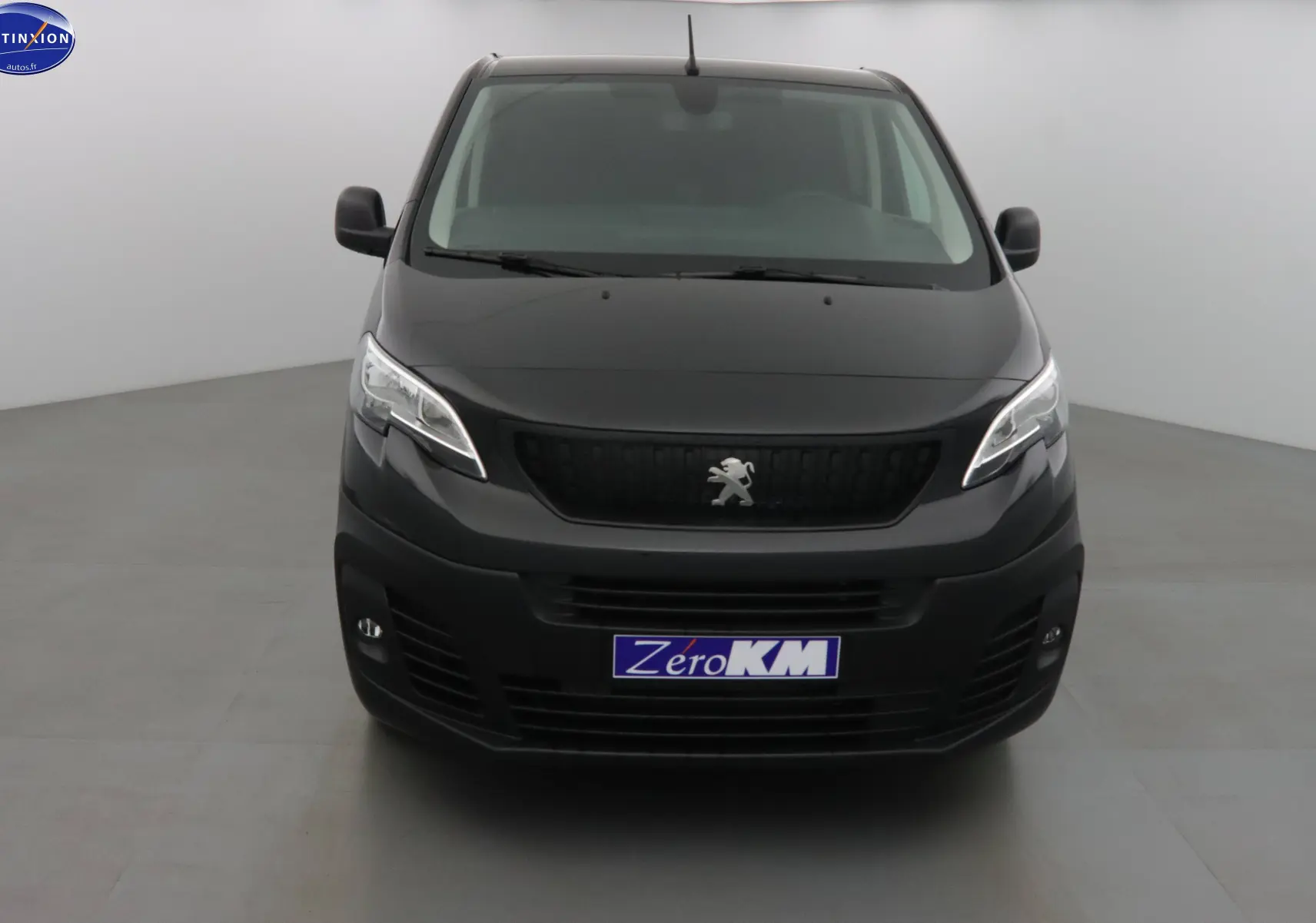 Vue frontale d'un Peugeot Expert Cabine Approfondie noir perle métal avec logo lion et plaque Zero KM visible.
