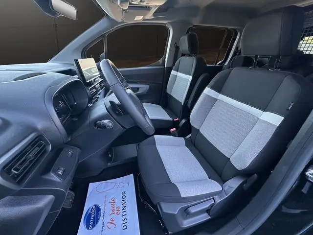 Vue intérieure côté conducteur du Citroën Berlingo N1 noir 2025, sièges bi-ton gris et noir avec tableau de bord moderne.