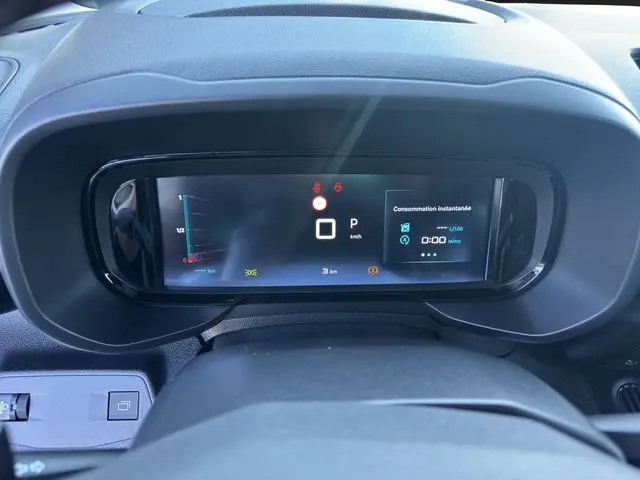 Tableau de bord numérique du Citroën Berlingo N1 BlueHDi 130 2025, affichant la consommation instantanée et la vitesse à l'arrêt.