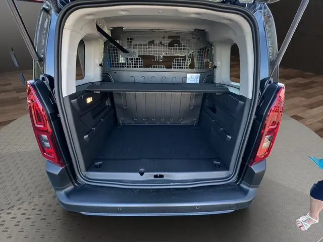Vue arrière du Citroën Berlingo N1 BlueHDi 130 noir 2025 avec hayon ouvert montrant l'espace de chargement et la cloison métallique.