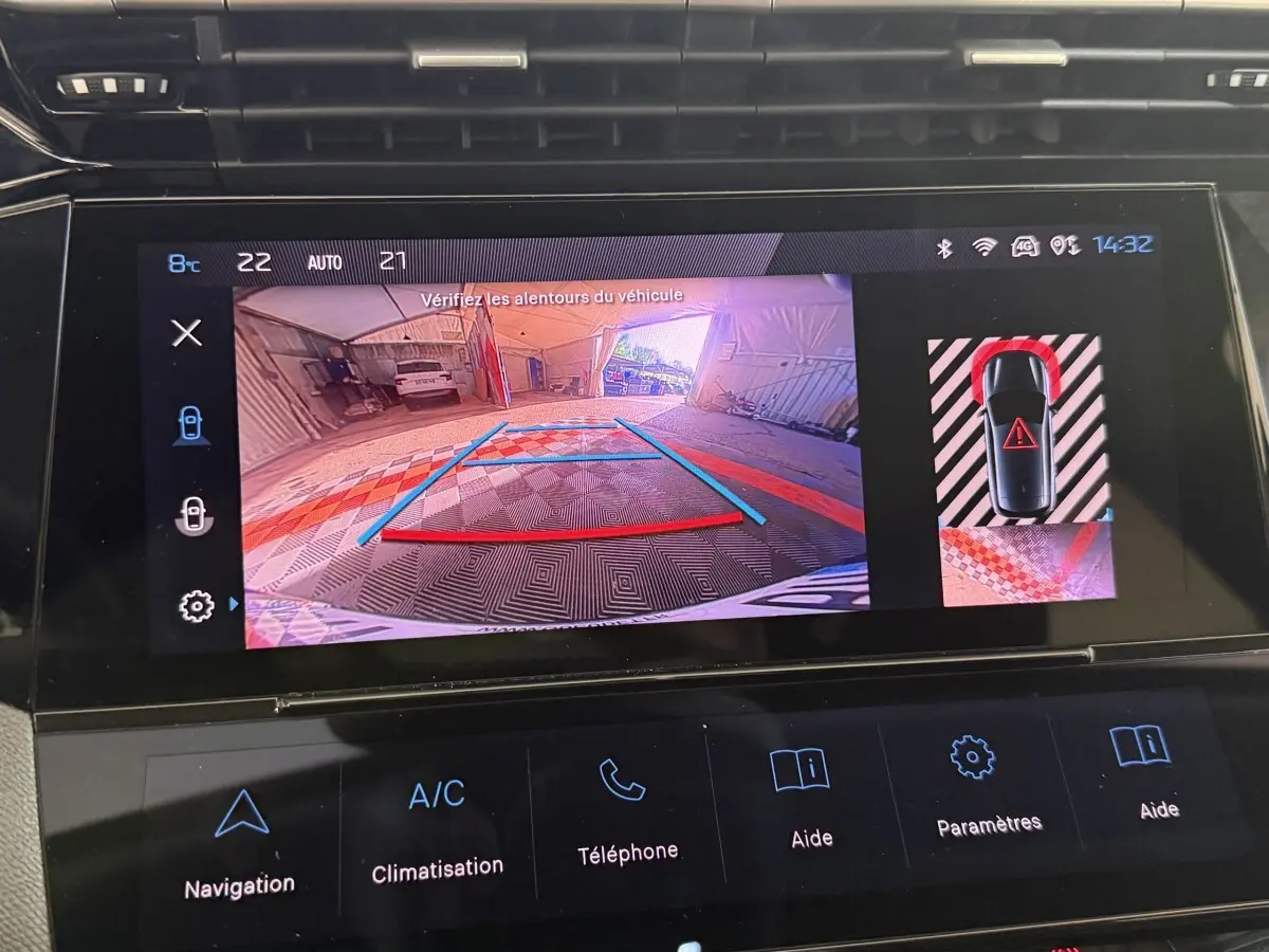 Écran tactile intérieur montrant la caméra de recul et l’aide au stationnement du Peugeot 308 bleu, vue arrière.
