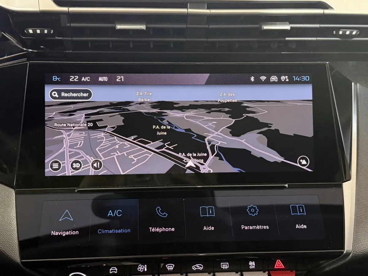 Vue rapprochée de l’écran tactile central du tableau de bord de la Peugeot 308 bleu, affichant la navigation 3D.