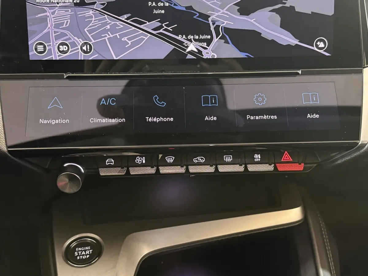 Vue rapprochée du tableau de bord tactile noir de la Peugeot 308 bleu 2023 avec commandes climatisation et navigation.