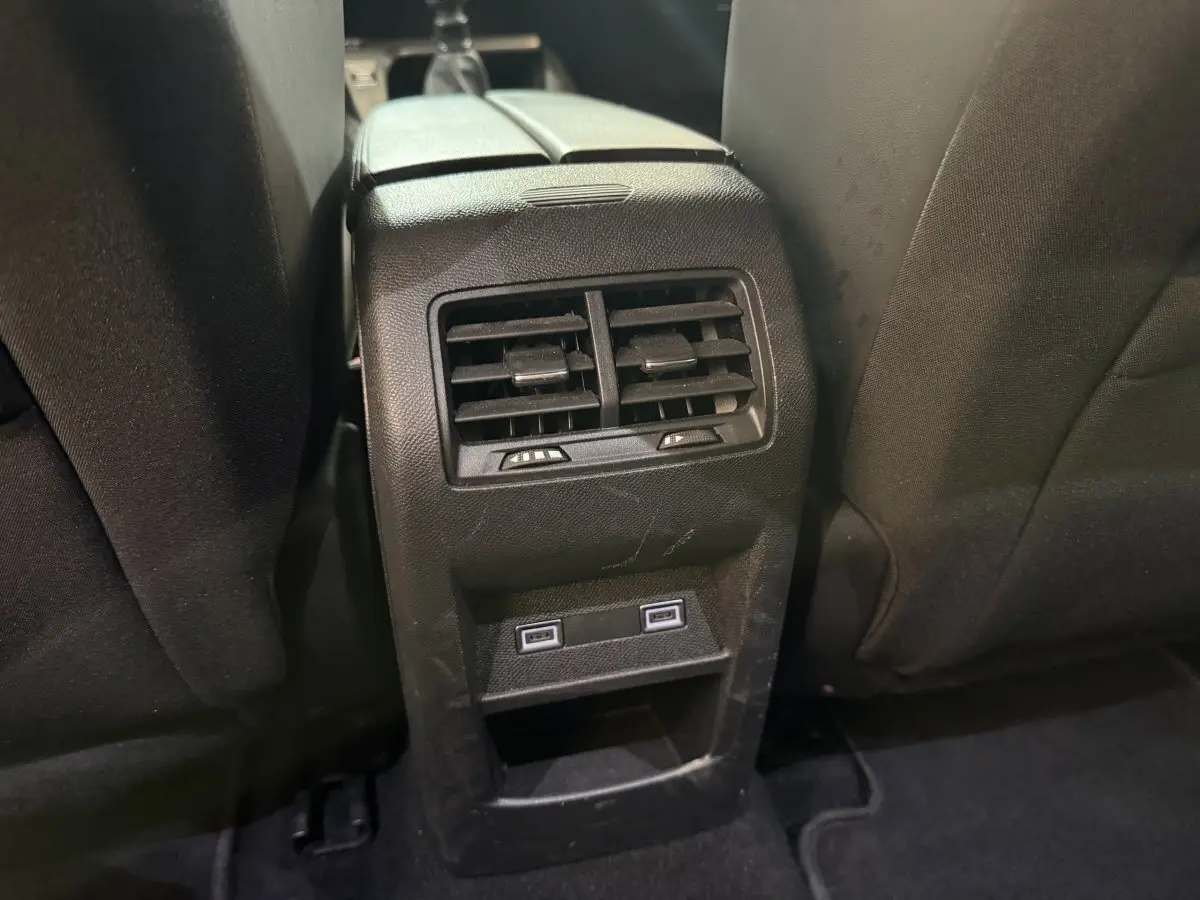 Vue rapprochée des aérateurs arrière et ports USB intégrés entre les sièges noirs d'une Peugeot 308 2023.