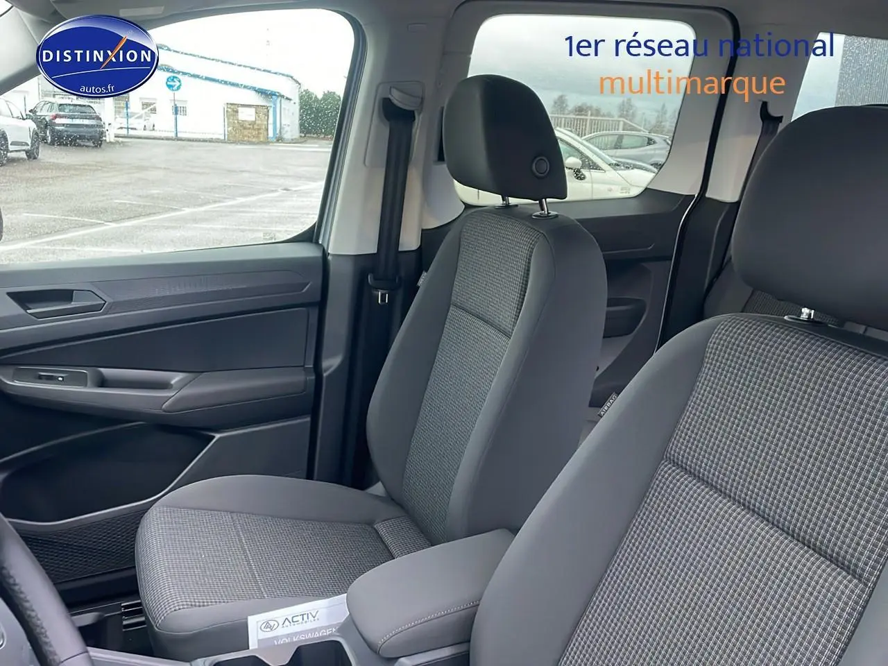 Vue intérieure sur les sièges avant gris tissu à motif double grid du Volkswagen Caddy 2025, côté gauche visible.