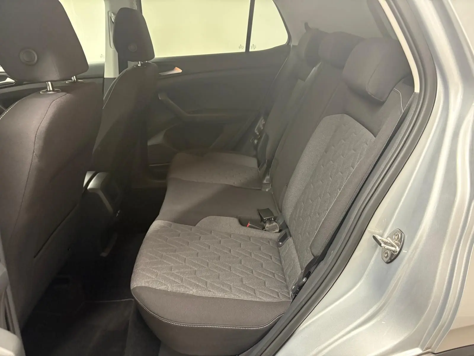 Vue côté droit sur la banquette arrière tissu gris et noir du Volkswagen T-Cross 2024 couleur reflet d'argent.
