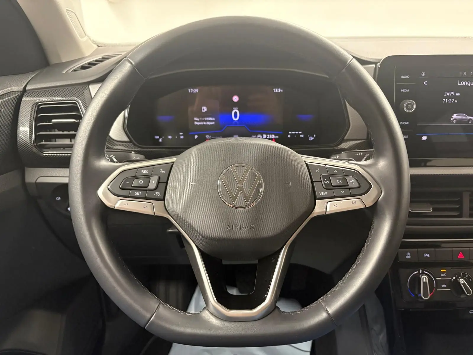Vue intérieure centrée sur le volant cuir noir et le tableau de bord digital du Volkswagen T-Cross 2024.