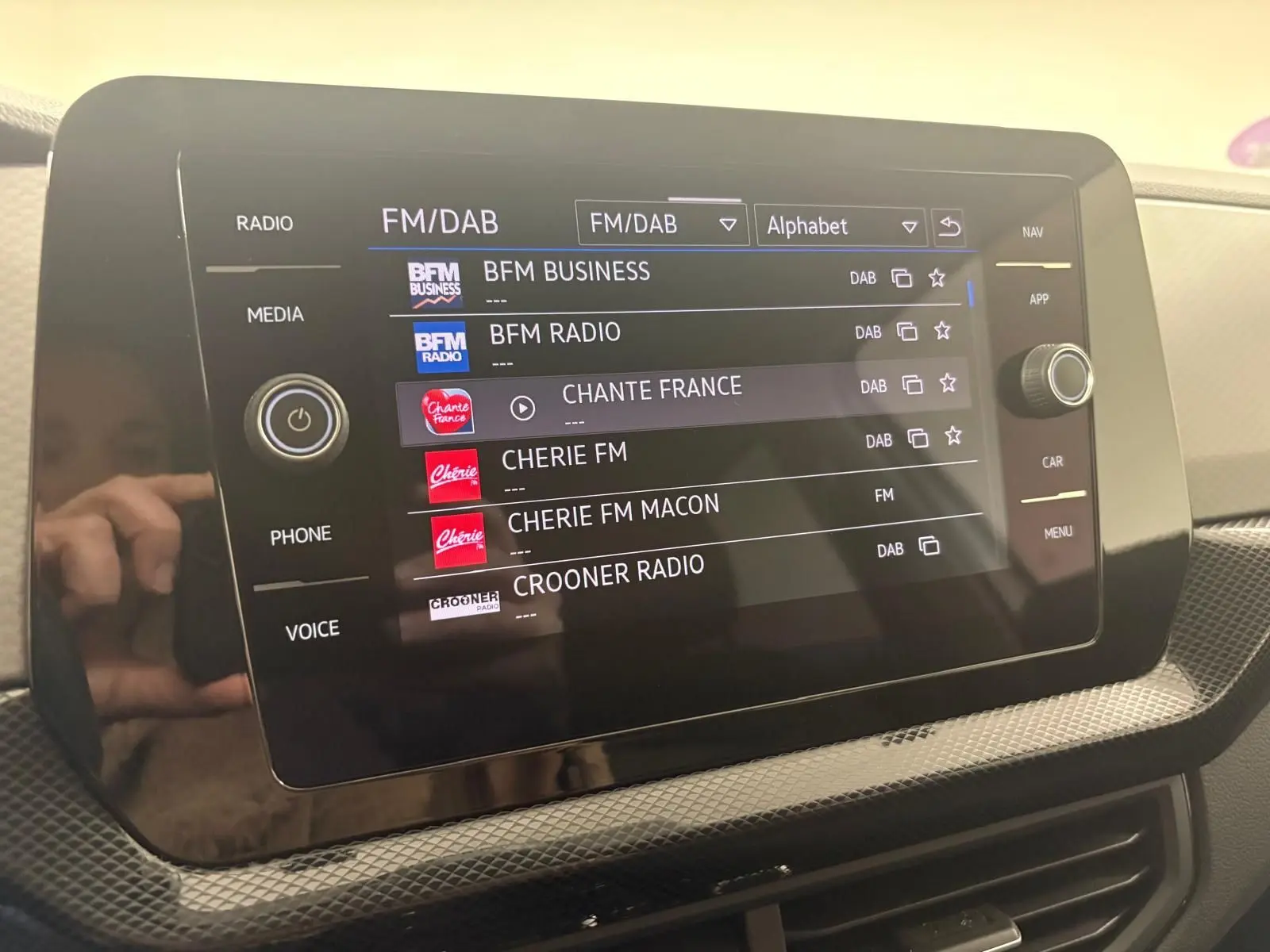 Écran tactile central affichant les stations radio FM/DAB dans l'habitacle du Volkswagen T-Cross 2024.