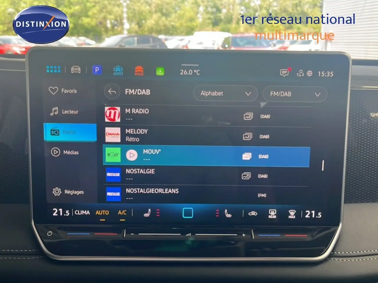 Écran tactile central du Volkswagen Tiguan 2026 affichant les options radio FM/DAB avec interface moderne et climatisation réglée.