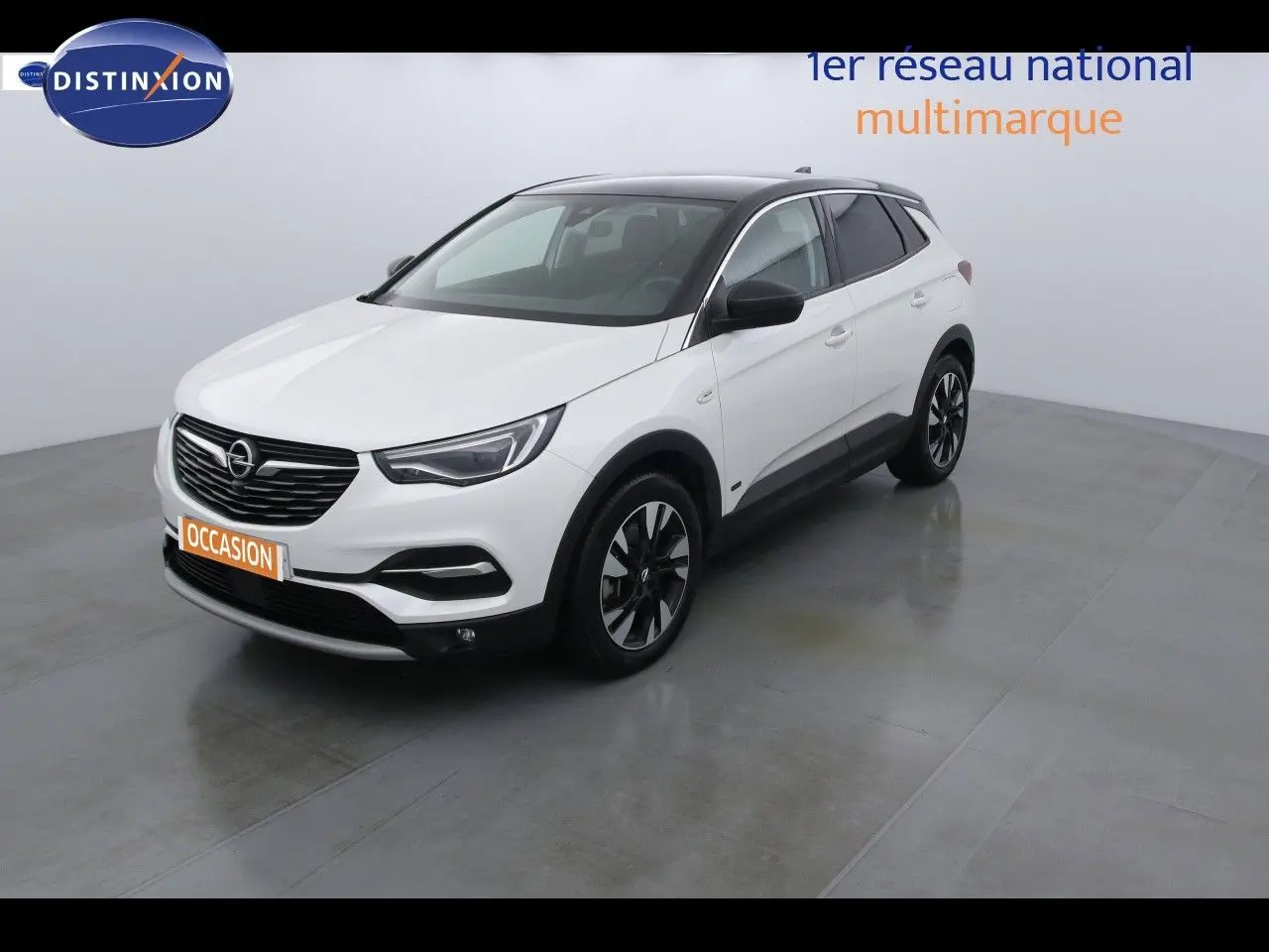 Opel Grandland X blanc nacré métal en 3/4 avant droit, toit noir et jantes alliage bicolores visibles.