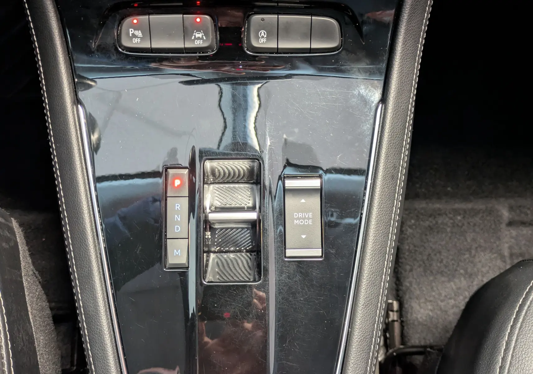 Gros plan sur la console centrale noire brillante de l’Opel Grandland 2023 avec commandes de boîte auto et mode de conduite.