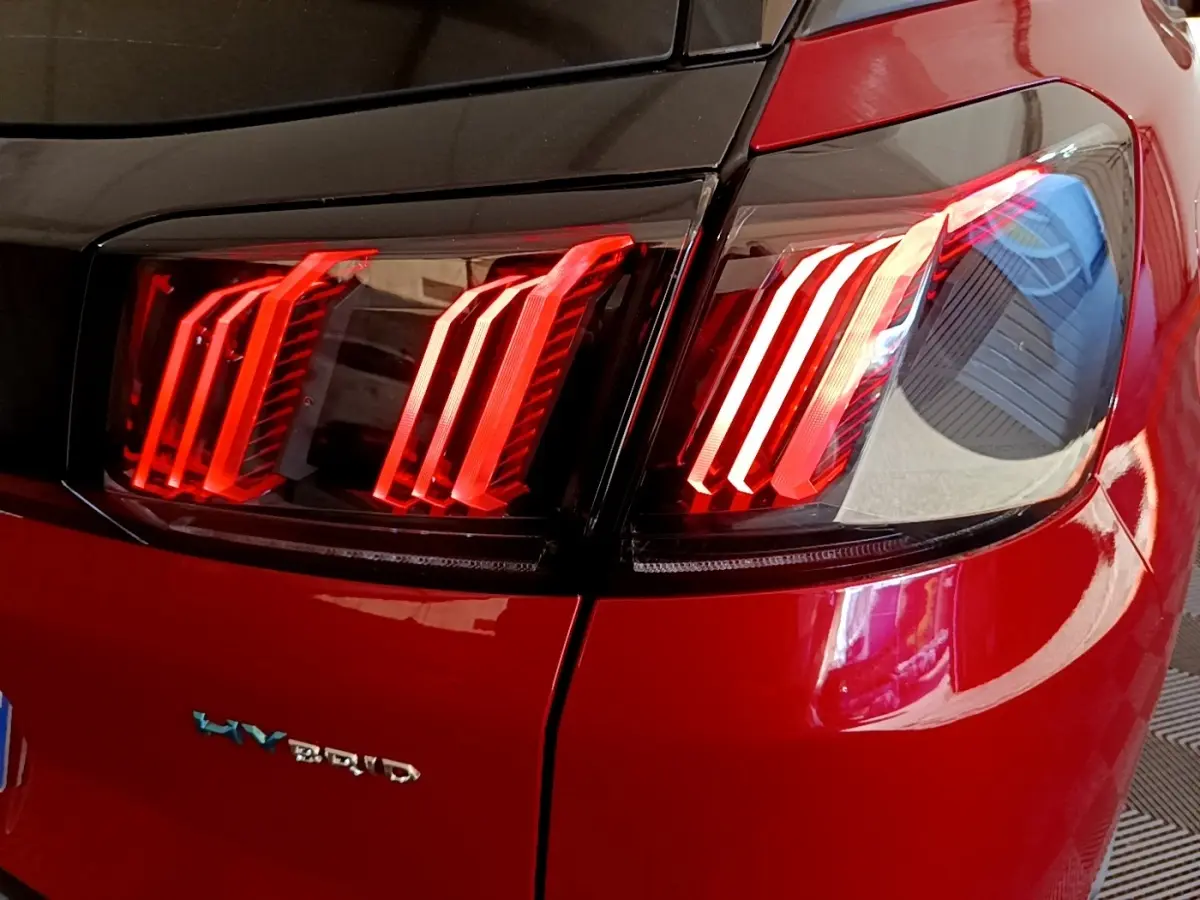 Gros plan sur le feu arrière droit rouge brillant d’un Peugeot 3008 hybride rechargeable de 2021.