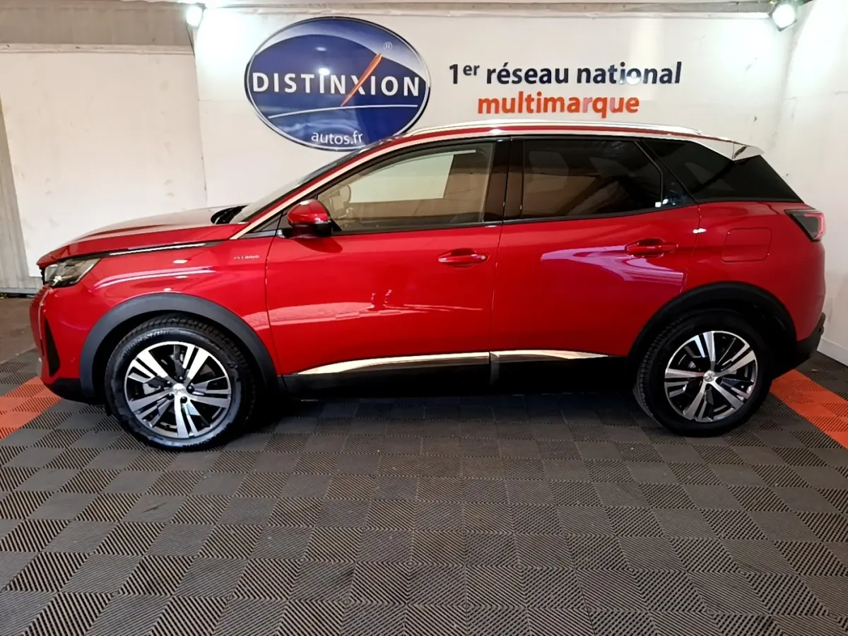 Vue de profil côté gauche d’un Peugeot 3008 hybride rechargeable rouge avec jantes alliage et toit noir.