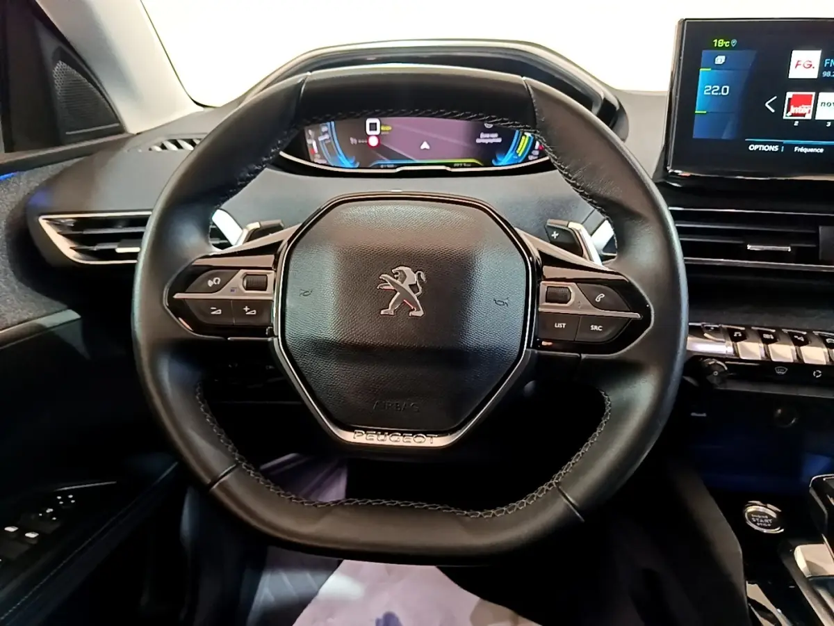 Vue frontale du volant cuir noir du Peugeot 3008 hybride rechargeable 2021 avec tableau de bord digital et écran tactile.