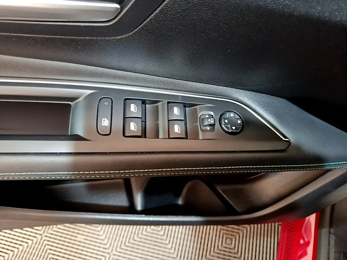 Gros plan sur la commande des vitres et rétroviseurs côté conducteur du Peugeot 3008 hybride rechargeable, intérieur noir avec surpiqûres bleues.