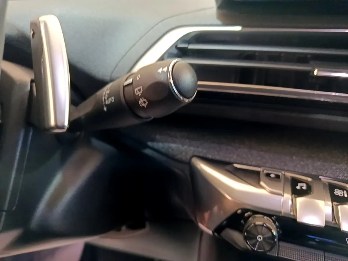 Gros plan sur la commande d’essuie-glace et la console centrale noire du Peugeot 3008 hybride rechargeable 2021.
