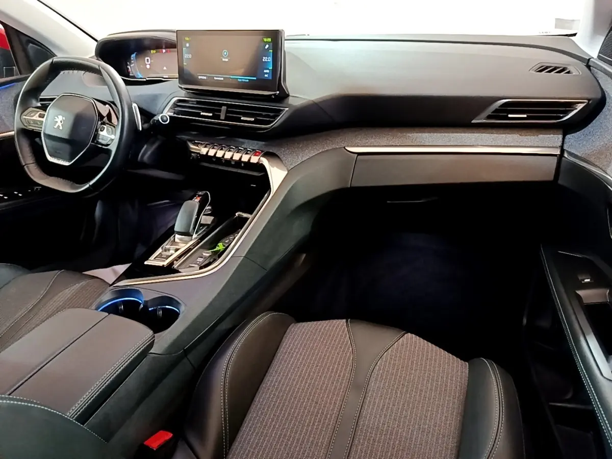 Intérieur noir et gris du Peugeot 3008 hybride, vue de côté droit sur le tableau de bord et console centrale avec écran tactile.