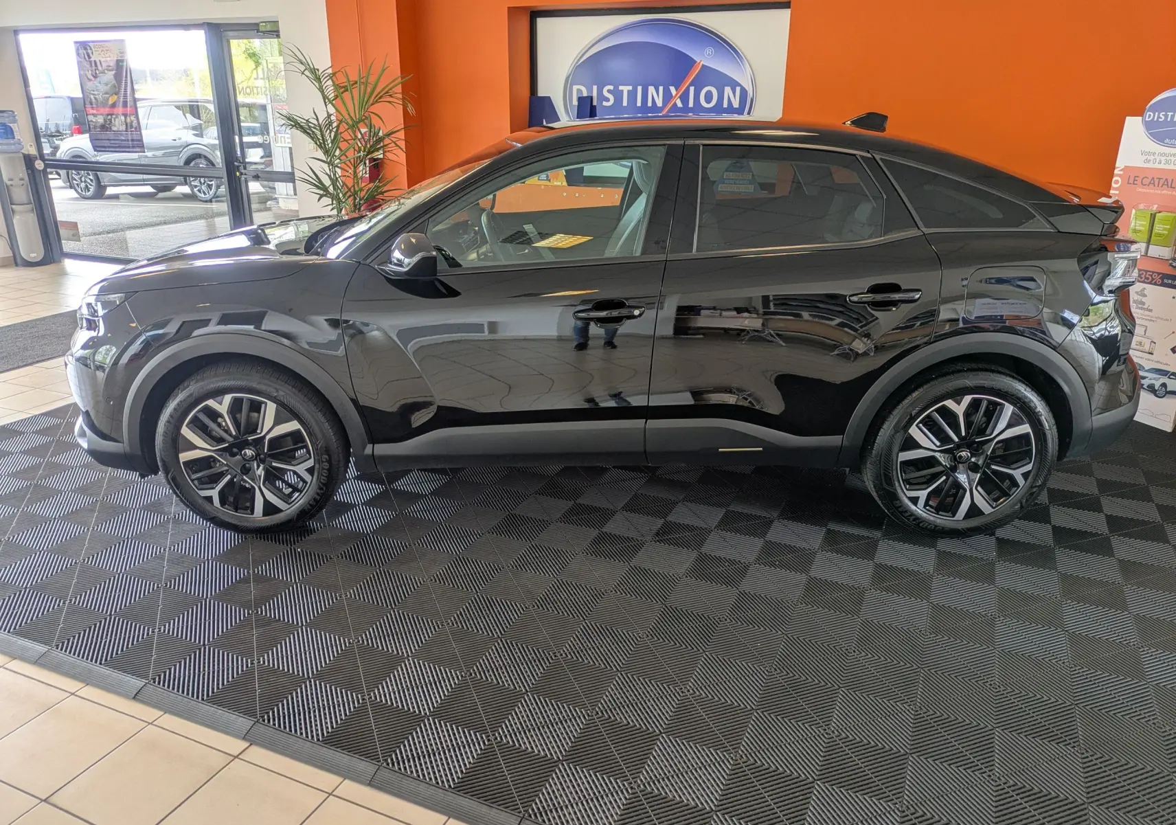 Silhouette stylisée d'une voiture en bleu et orange avec le texte "en arrivage", sans véhicule réel visible.