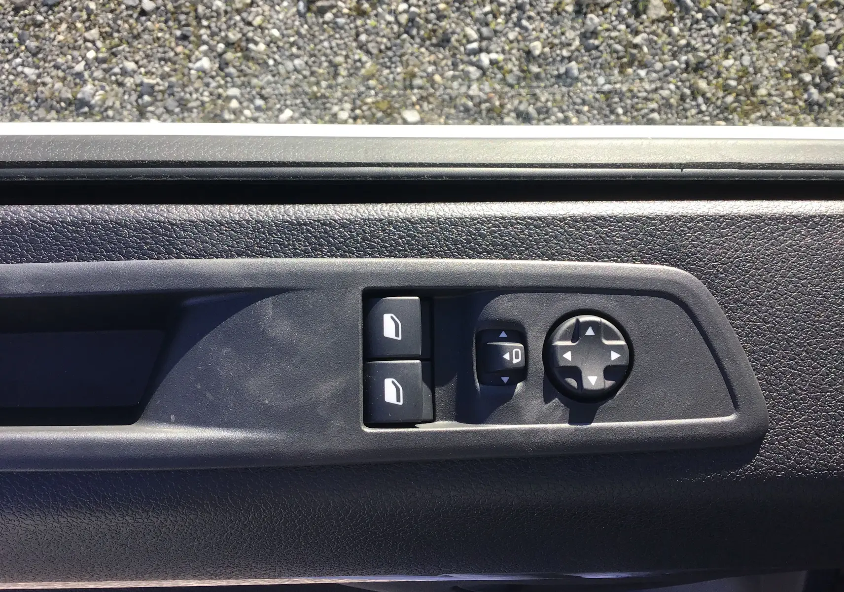 Gros plan sur les commandes de réglage des rétroviseurs et des vitres côté conducteur du Peugeot Expert Fourgon blanc 2024.