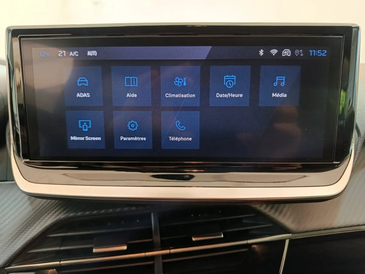 Écran tactile central de la Peugeot 208 PureTech 100 S&S Allure affichant les menus climatisation, aide et média.