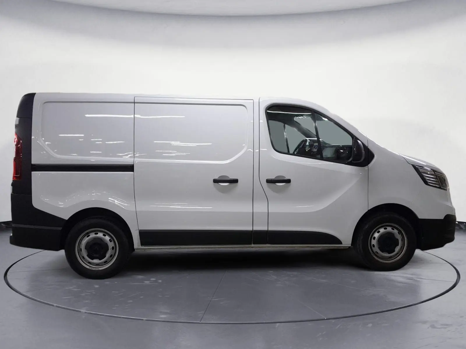 Profil droit du Renault Trafic Fourgon blanc 2024 avec portes tôlées et roues acier 16 pouces.