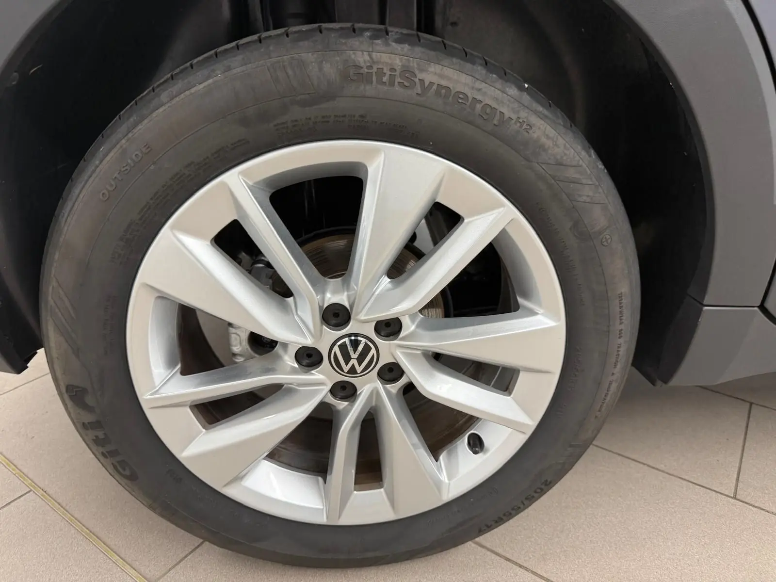 Gros plan sur la jante alliage argentée et le pneu GitiSynergy du Volkswagen T-Cross gris cendre, côté avant droit.