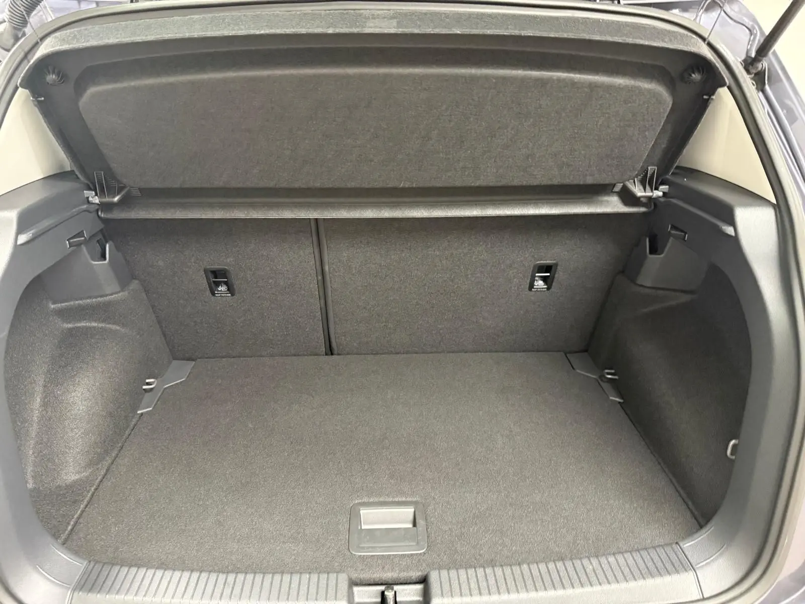 Coffre ouvert du Volkswagen T-Cross gris cendre 2025, montrant l'espace de chargement et la tablette arrière.