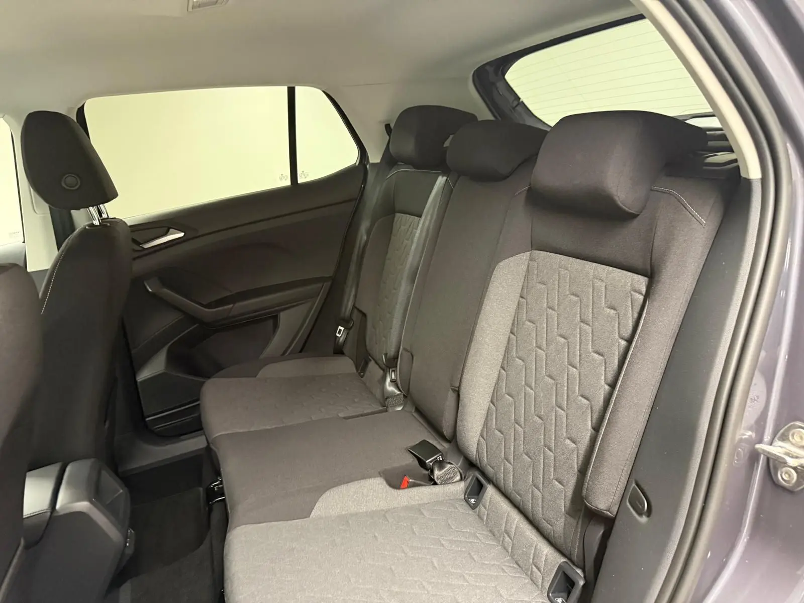 Vue intérieure côté droit des sièges arrière gris foncé et clair du Volkswagen T-Cross 2025 gris cendre, version VW Edition.