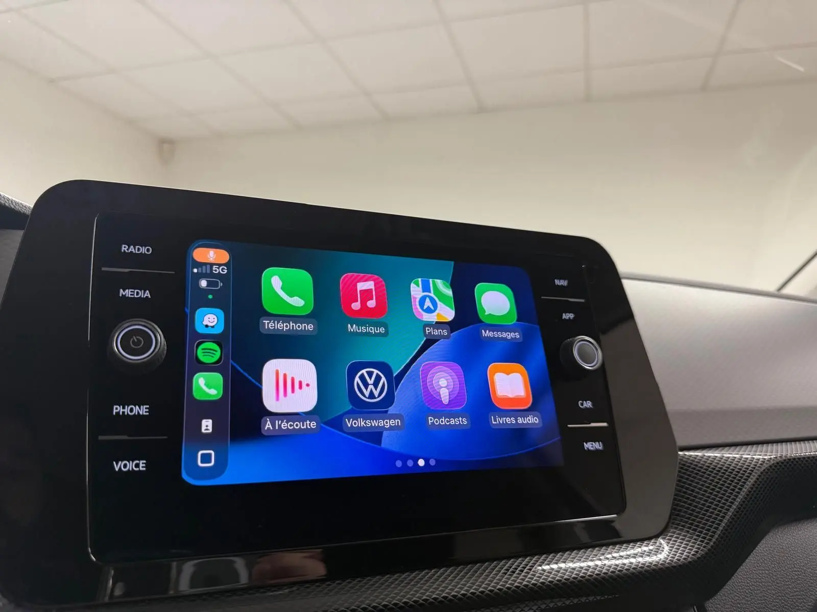 Écran tactile central du Volkswagen T-Cross 2025 affichant l’interface Apple CarPlay avec icônes colorées.