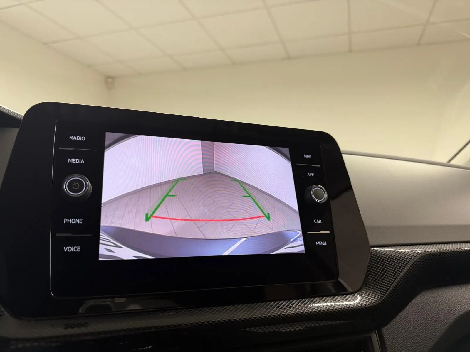 Écran central affichant la caméra de recul d’un Volkswagen T-Cross gris cendre, vue intérieure du tableau de bord.