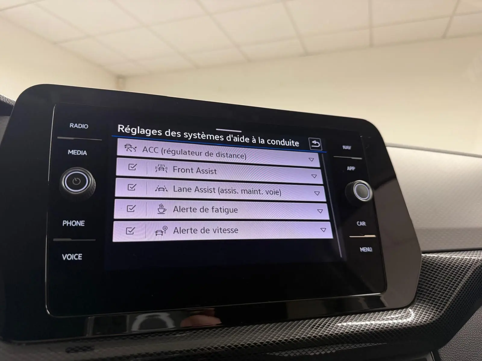 Écran tactile central du Volkswagen T-Cross gris cendre 2025 affichant les réglages des aides à la conduite.