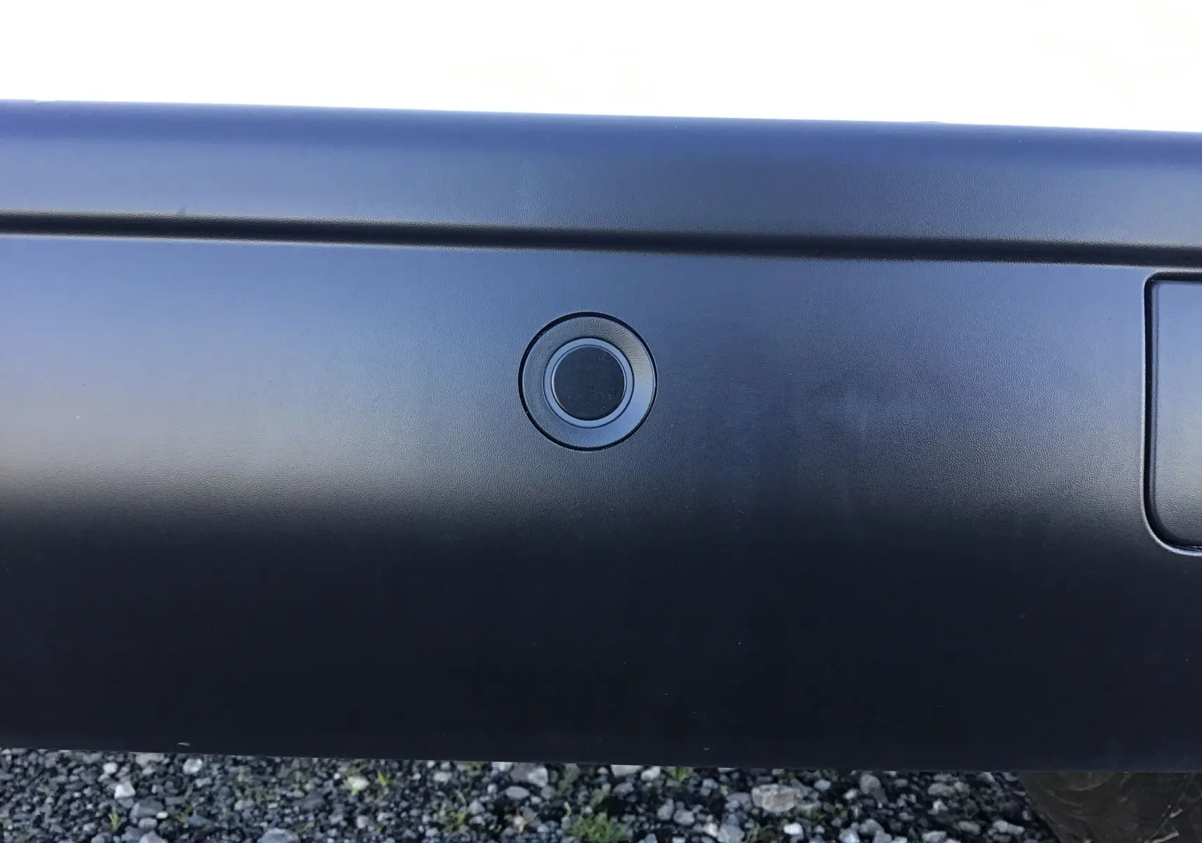 Gros plan sur un capteur de stationnement arrière noir du Peugeot Expert Fourgon blanc 2024.