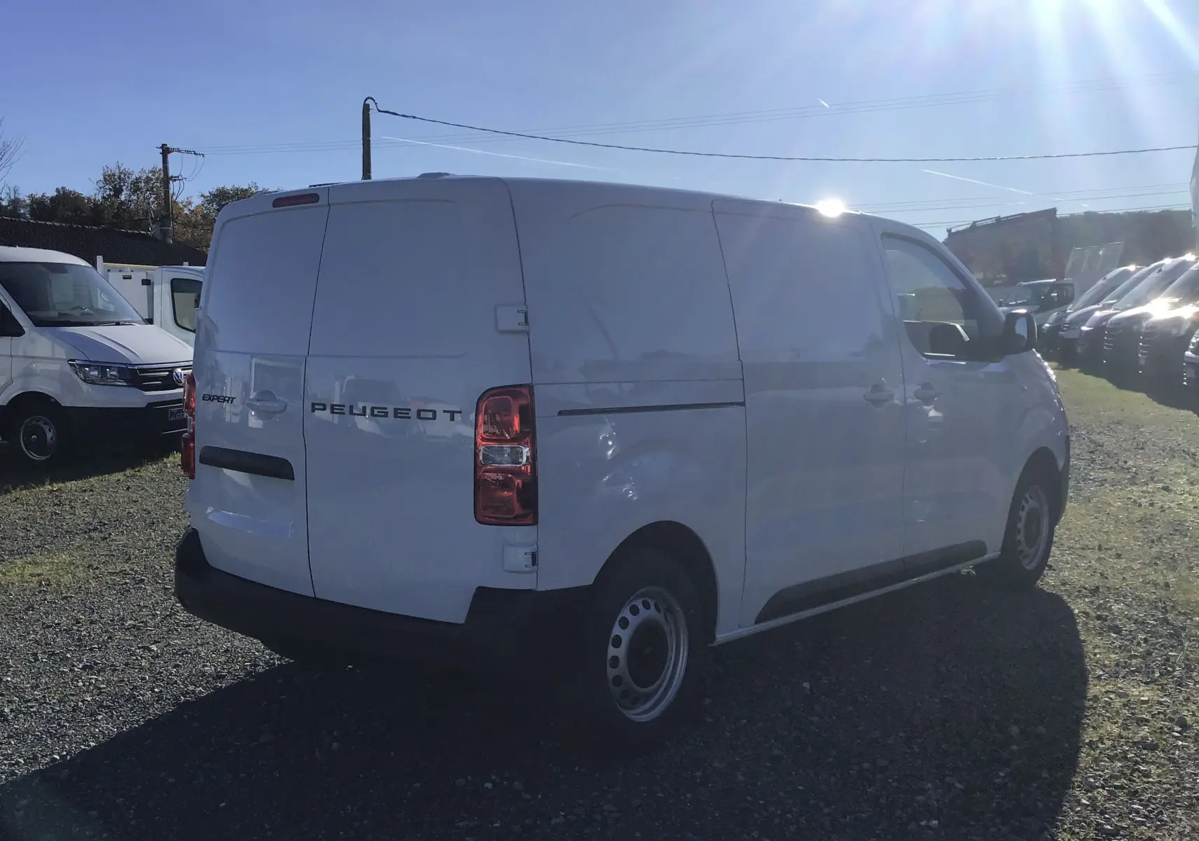 Vue 3/4 arrière droite d'un Peugeot Expert Fourgon blanc 2024, avec portes arrière fermées et jantes acier simples.