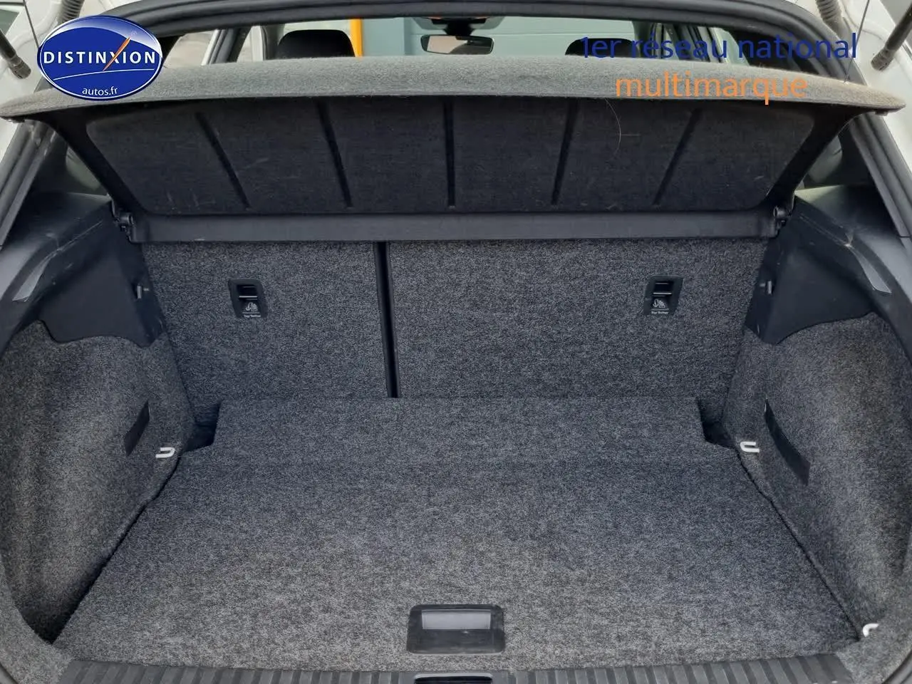 Coffre ouvert en vue arrière d'un SEAT Arona blanc, montrant l'espace de chargement tapissé de moquette grise.