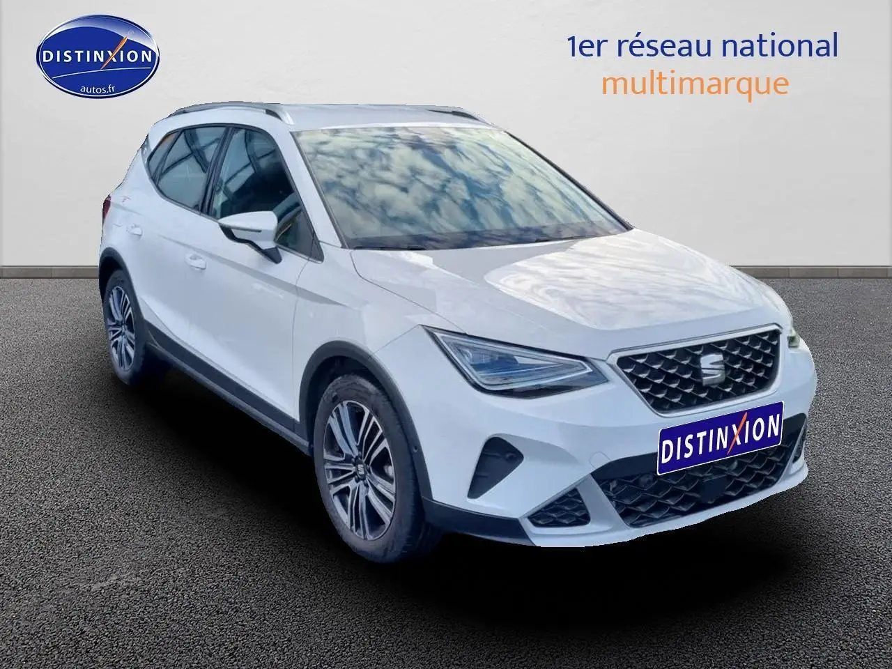 SEAT Arona blanc en vue 3/4 avant droit avec jantes alu 17 pouces et barres de toit visibles