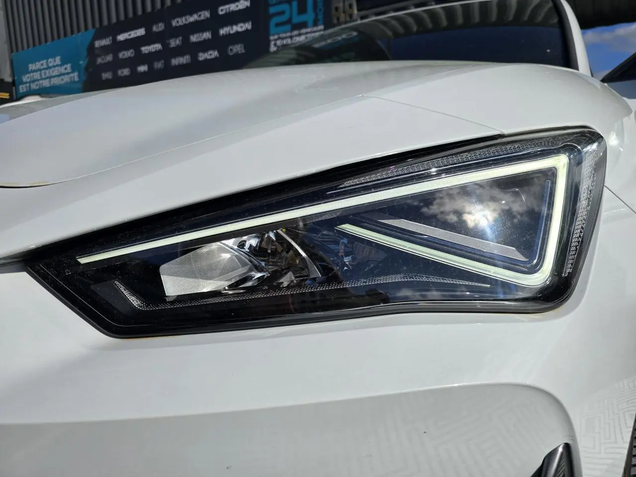 Gros plan sur le phare avant droit LED d'une CUPRA Leon Sportstourer blanc Nevada métallisé 2024.