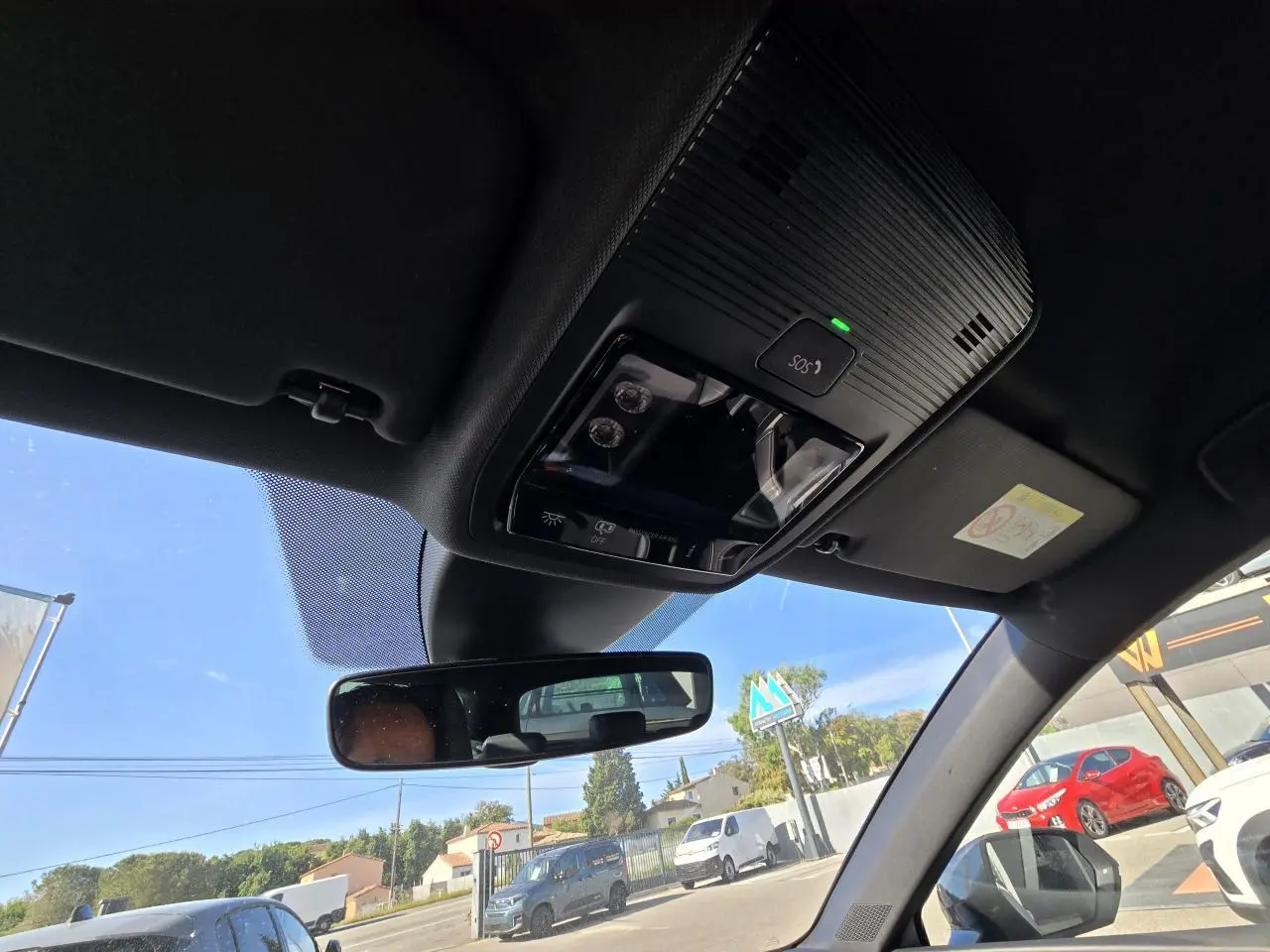 Vue intérieure du plafond avant avec commandes d'éclairage et rétroviseur dans une CUPRA Leon Sportstourer blanc Nevada.