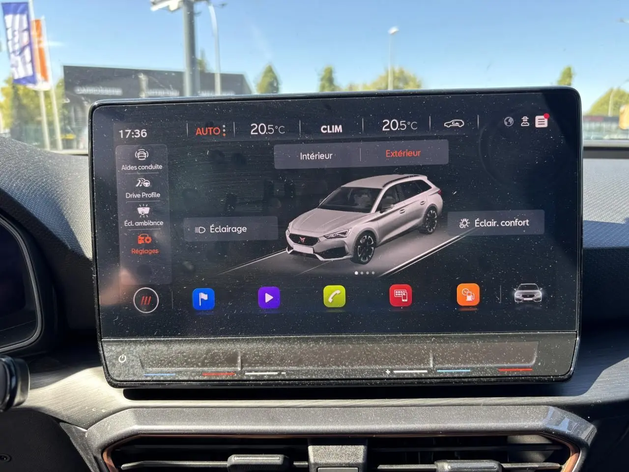 Écran tactile intérieur affichant une vue 3/4 avant d'une CUPRA Leon Sportstourer blanc Nevada métallisé.