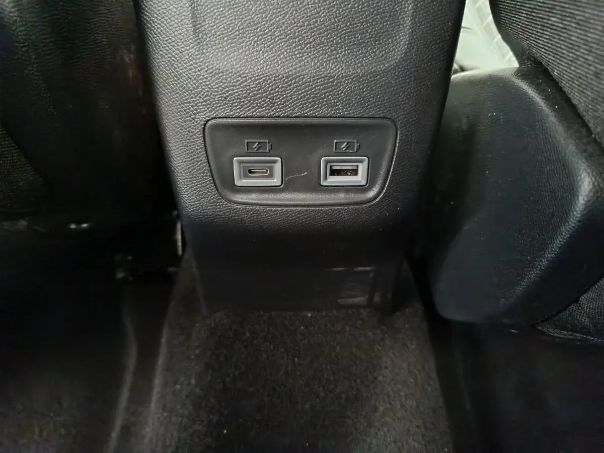 Prise USB Type-C et USB Type-A pour recharge à l'arrière d'un Peugeot 208 gris clair, intérieur noir.