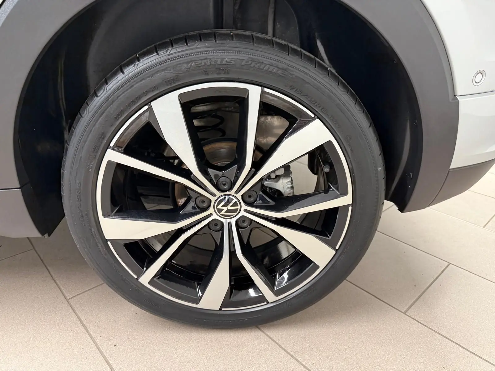 Gros plan sur la jante alliage 18'' bicolore noir et argent du Volkswagen T-Cross 1.5 TSI R-Line couleur Reflet d'Argent.